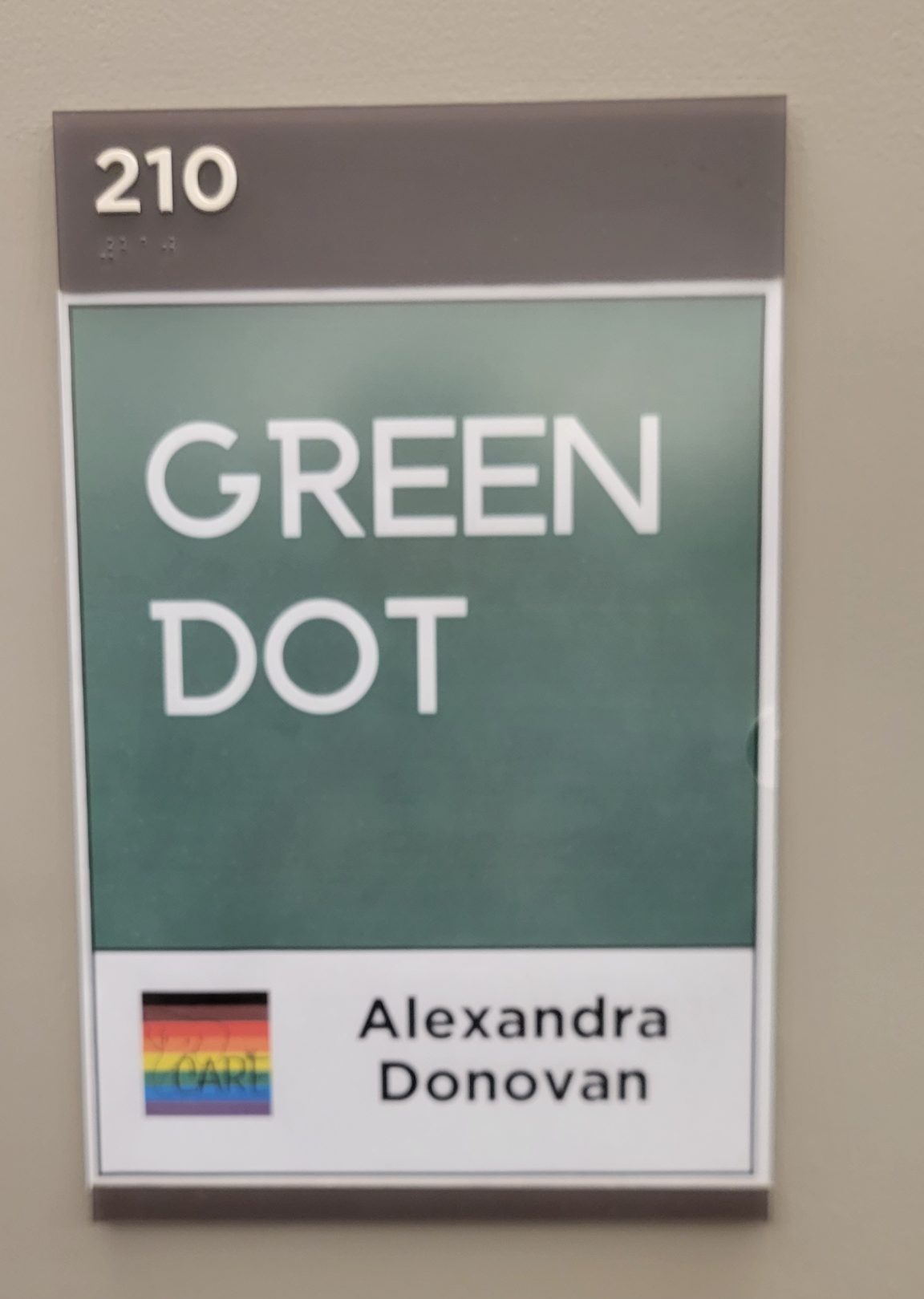 Green sign that says Green Dot. Underneath on a white background it says Alexandra Donovan.