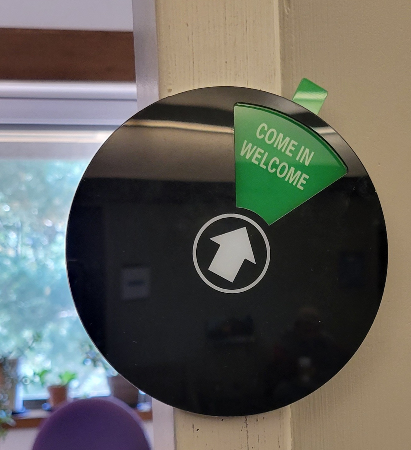 Black circle with a green triangle at its top that says "come in welcome"